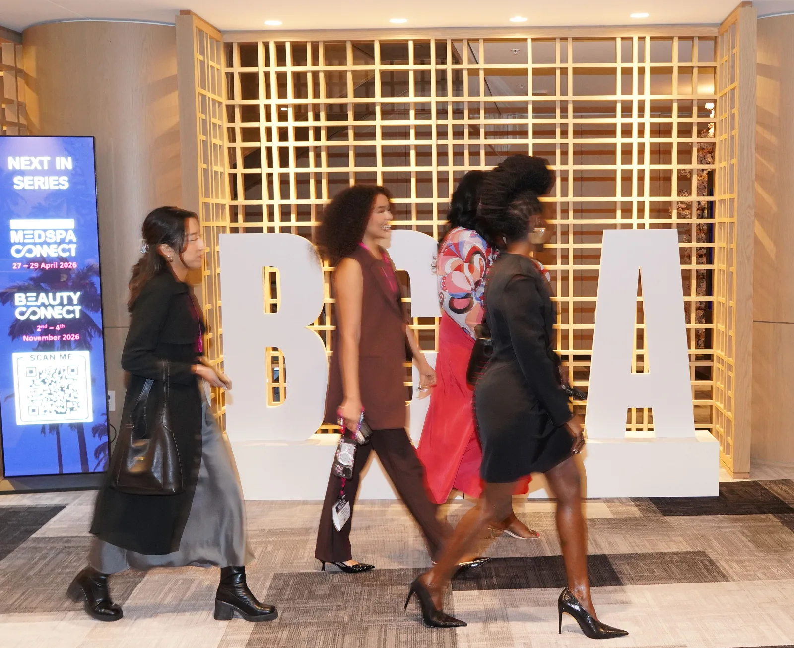 Attendees walking past the Beauty Connect LA sign