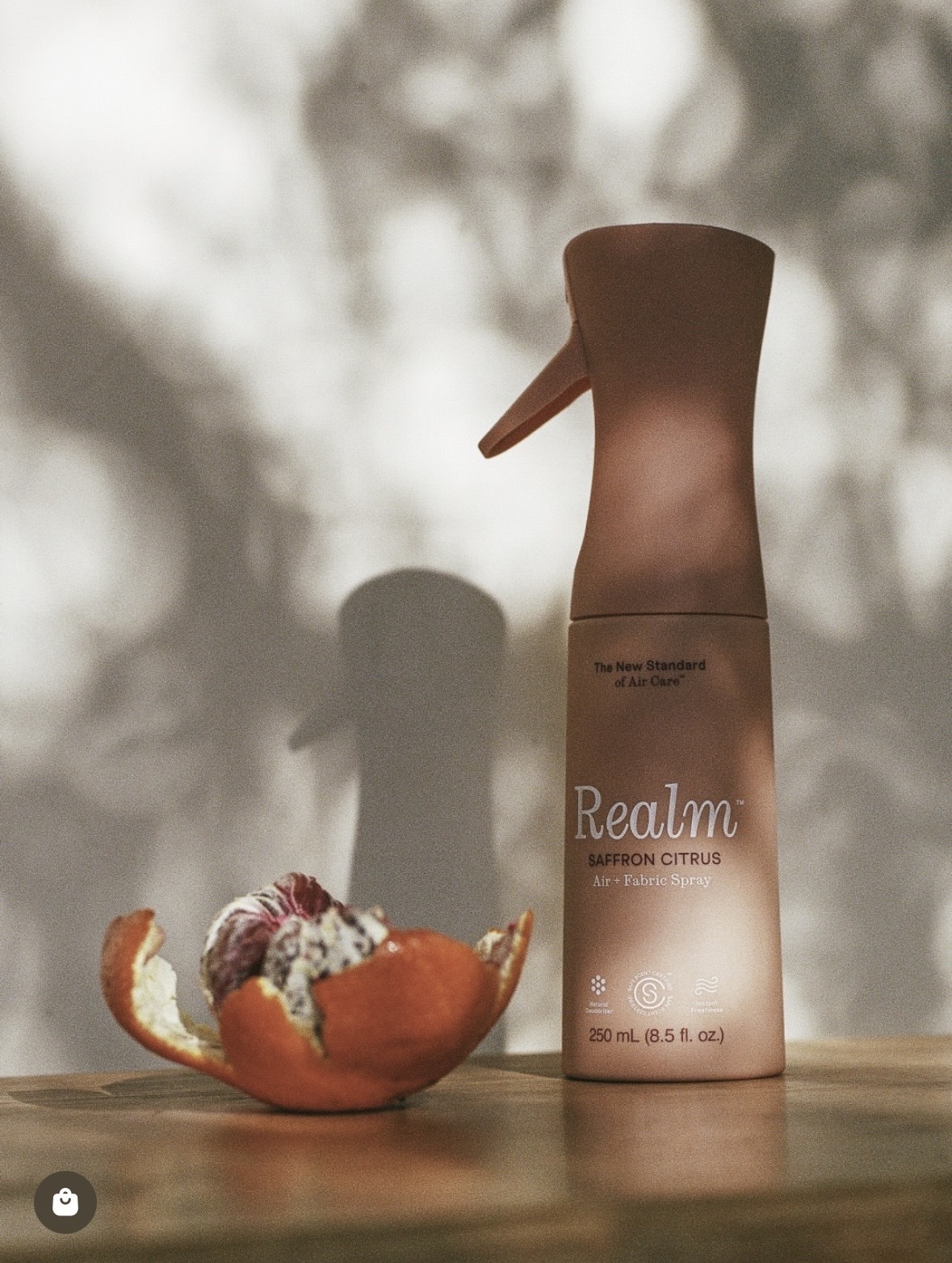 Realm Saffron Citrus air and fabric spray with a peeled orange